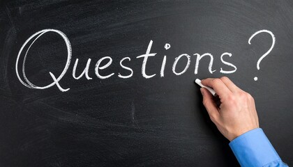 "Questions?" written in chalk on blackboard by hand.