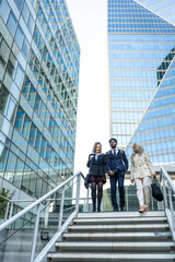 Diverse business professionals walking down stairs in financial district © unai