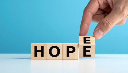 Hand places final "E" block to complete HOPE on blue.