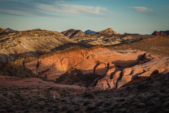 View of fiery red and grey sandstone formations contrasting sharply under a clear sky, carved by time and weather in a vast, arid landscape, Overton, Nevada, United States.