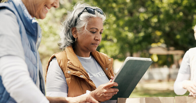 Woman, volunteer and reading with tablet outdoor for charity, checklist and community service. Mature person, digital and donation inventory for food drive, humanitarian outreach and event schedule