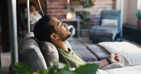 Man, sleep and iv drip in clinic for healthcare, iron infusion and immune booster on couch. Male patient, rest or intravenous solution in medical lounge for treatment, hydration therapy or body detox