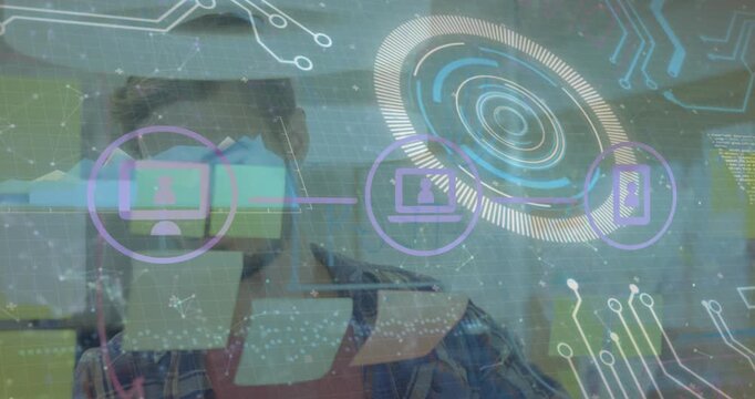 Animation of connected icons, circles, graph on caucasian man sticking notes on glass wall