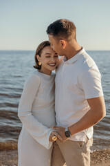 Happy young couple on the beach. Pregnant woman and man on a walk. Family expecting a child.