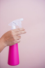 The hand holding the spray bottle.