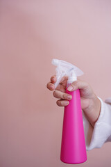 The hand holding the spray bottle.