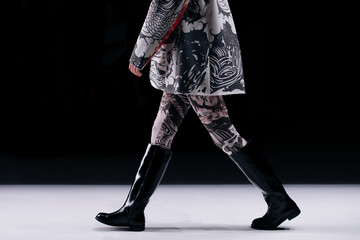 Fashion creative details of black white jacket and leather boots, fancy cloth on black background