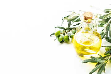 Olive oil in the bottle at white table.