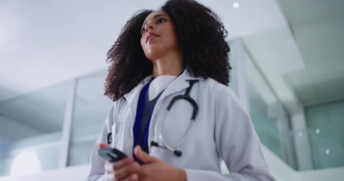 Woman, doctor and walking in clinic with phone for schedule check, text message and medical update. Low angle, person and healthcare worker in hospital with tech for email, research and reading news.