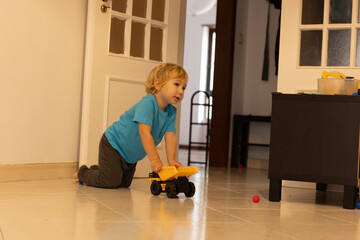 Young child playing with toy dump truck on floor