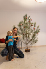 Mother and son decorating christmas tree with ornaments