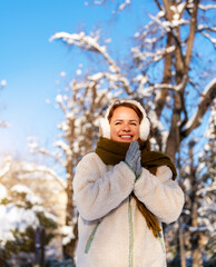 Joyful young woman walking strolling in cozy winter clothes