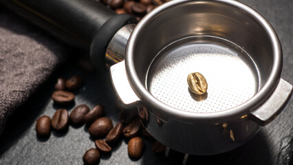 Single golden coffee bean placed in an espresso portafilter, surrounded by gold-colored...