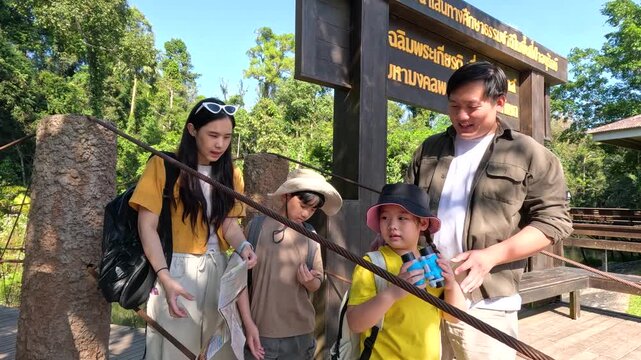 Asian Family Planning a Hike with a Map in Khao Yai National Park
