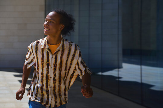 Cheerful person walking outdoors in urban summer environment