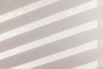 窓から差し込む柔らかい陽光とブラインドの影が作る壁の背景素材