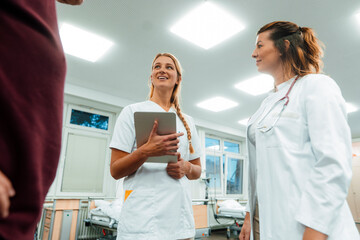 Nurse and doctor consulting with patient in hospital rehabilitation setting