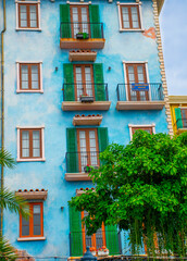 Naklejka premium colorful residential buildings with balconies and palm trees, reflecting mediterranean architecture and vibrant urban lifestyle.