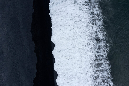 Aerial view of black sand beach and ocean waves in Hvalnes Nature Reserve