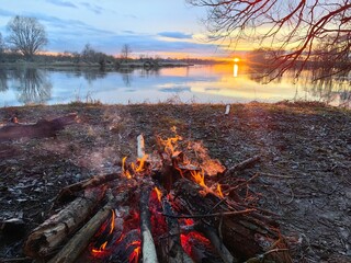 Sunset on the river with a fire, early spring.