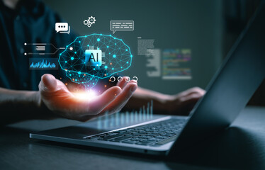 Artificial intelligence concept with glowing AI brain hovering above a human hand and laptop, representing data processing, machine learning, neural networks, digital innovation, business technology.