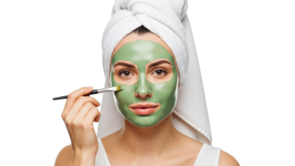 Woman with green face mask and towel on head applying mask with brush isolated on transparent background