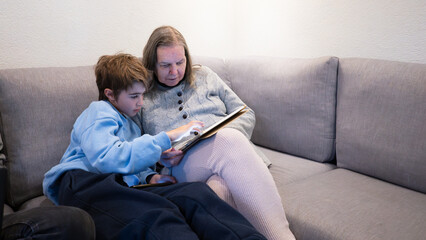 Grandson and grandmother sharing digital tablet at home