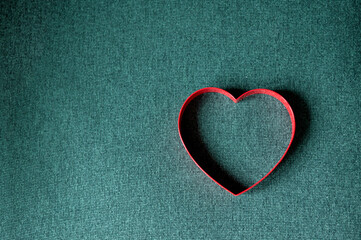 top view of red heart on green background with copy space.