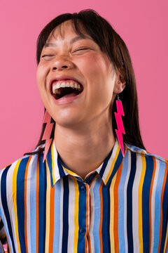 Beautiful asian woman portrait, asian woman laughing with colorful striped shirt and lightning earrings
