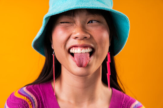 Beautiful asian woman portrait, young asian woman winking sticking out tongue