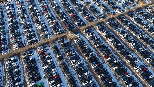 Aerial view of cars tightly packed in rows, creating a mesmerizing grid of color and texture with snow, Corby, England, United Kingdom.