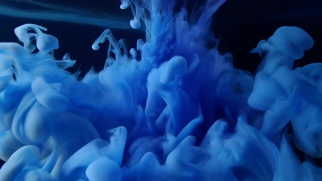 Abstract blue ink cloud swirling underwater deep dark background ethereal smoke diffusion slow motion organic abstract motion liquid paint explosion