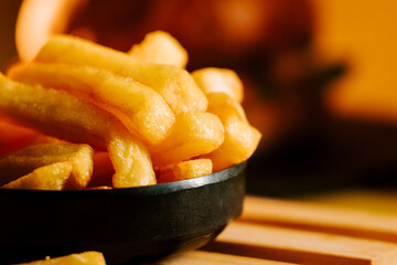 Enjoying fresh French fries on a black plate in a cozy restaurant setting during lunchtime