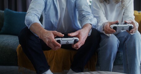 Senior man plays video game using joysticks at home