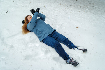 Adult woman falling backward on snow after slipping in winter
