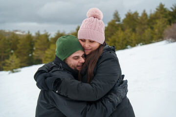 Loving couple embracing in a snowy winter mountain landscape