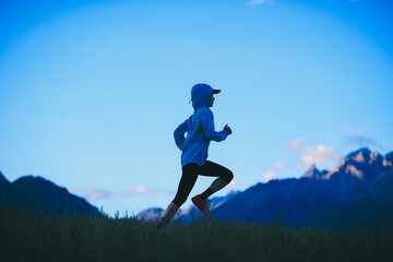 Woman runner running at  the beautiful grassland mountain top