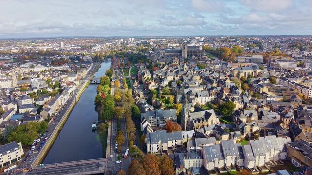 Aerial ascend along La Sarthe river with reflections and Saint Julien Cathedral dominating the historic skyline, panoramic establish
