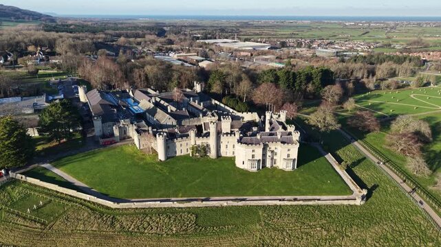 Stunning medieval Bodelwyddan Castle slow drone clockwise rotate from far on a sunny winter day, revealing the marble church, North Wales, UK