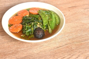 fried mixed vegetable dressing sesame oil and soy sauce with chop garlic on plate