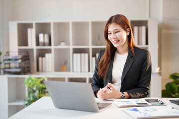 Young Asian businesswoman having an online video conference call on her laptop, collaborating and communicating remotely from her modern office workspace