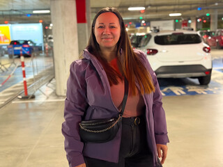 Woman in purple jacket at parking garage
