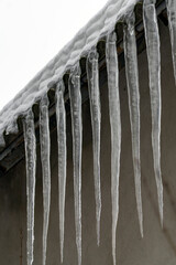 Icicles hang from a roof during winter in a residential area showing cold weather and snow conditions