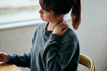 Woman Suffering from Shoulder Pain While Working on Laptop in Home Office