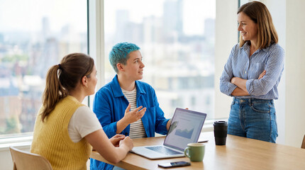 Three business colleagues discussing project on laptop in modern office space together