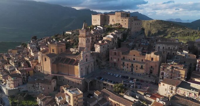 Aerial view of Caccamo reveals the ancient castle perched atop the hill, overlooking the town with its terracotta rooftops, Caccamo, Sicily, Italy.
