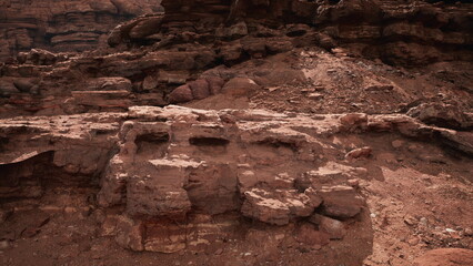 A winding path cuts through a majestic canyon with towering rock formations. The warm glow of sunset illuminates the rugged terrain, revealing natures beauty.