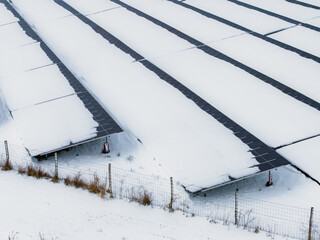 Snow covered solar panels in winter aerial view