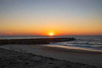 Sunset over the Atlantic Ocean with sandy beach and stone breakwater in Furadouro Portugal, Ovar &ndash; Furadouro, 11 November 2025