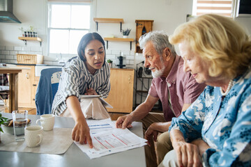 Financial advisor meeting with senior couple at home kitchen table